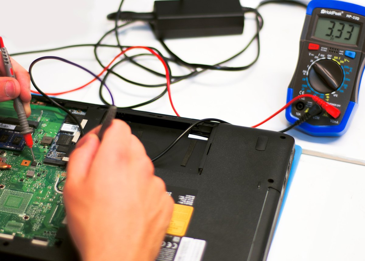 Elektrische Messung an einem Notebook-Mainboard mit Multimeter