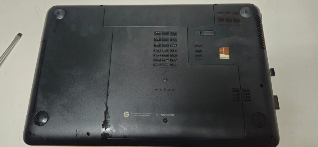Unterseite des HP Pavilion 17-e015sg mit sichtbaren Gebrauchsspuren und Verschmutzung