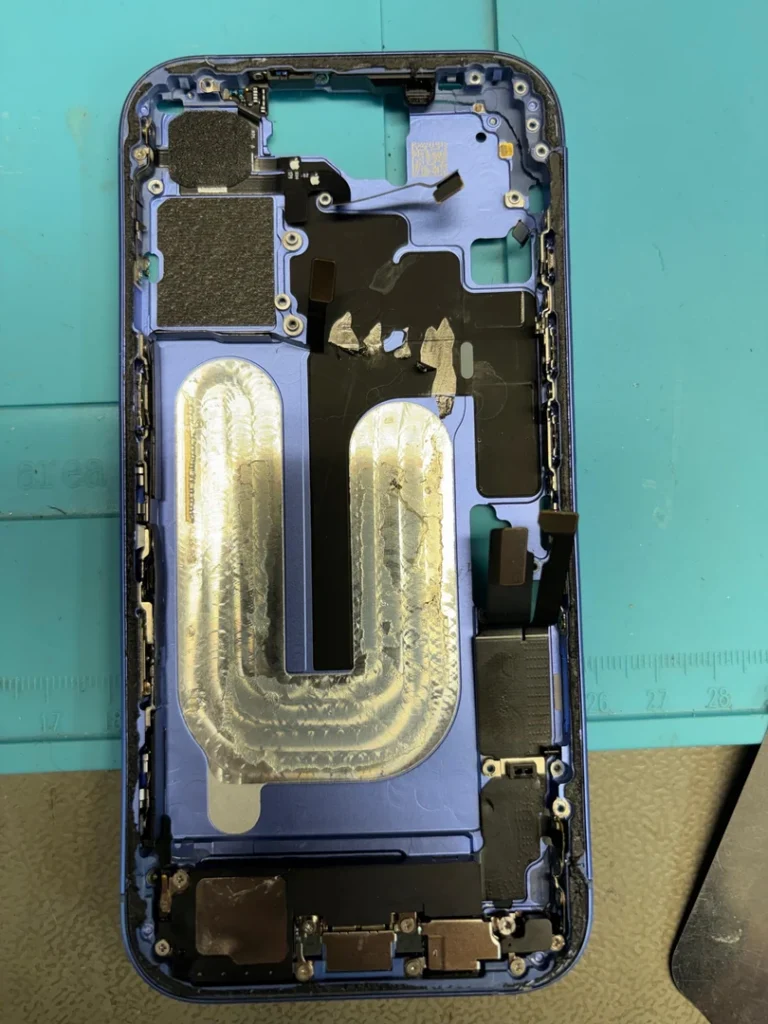 Weitgehend leeres blaues Gehäuse des iPhone 16 nach der Demontage